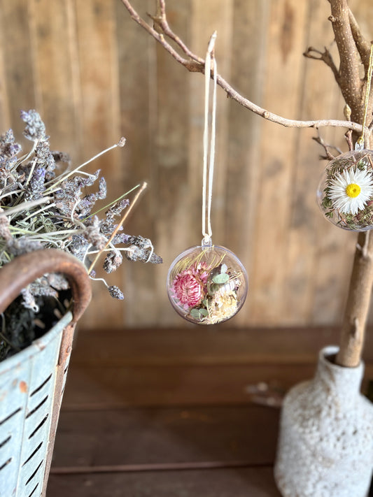 Close-up of a shatterproof botanical bauble filled with dried Australian native flowers