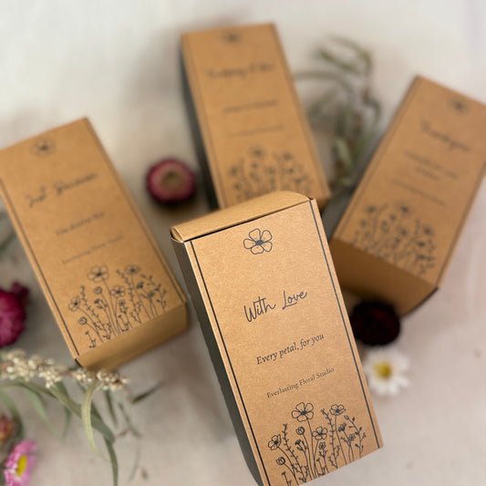 Three brown boxes with floral designs and text on a light background