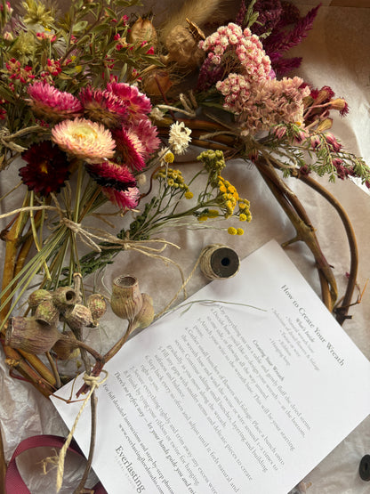 Mothers Day Gift idea - Dried flowers and branches on a textured surface with an open book.