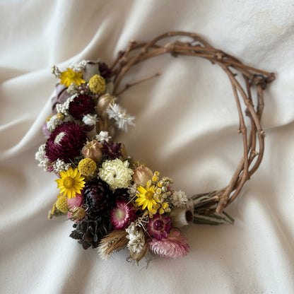 Wreath made of native dried flowers and everlasting daisies on a natural grapevine base
