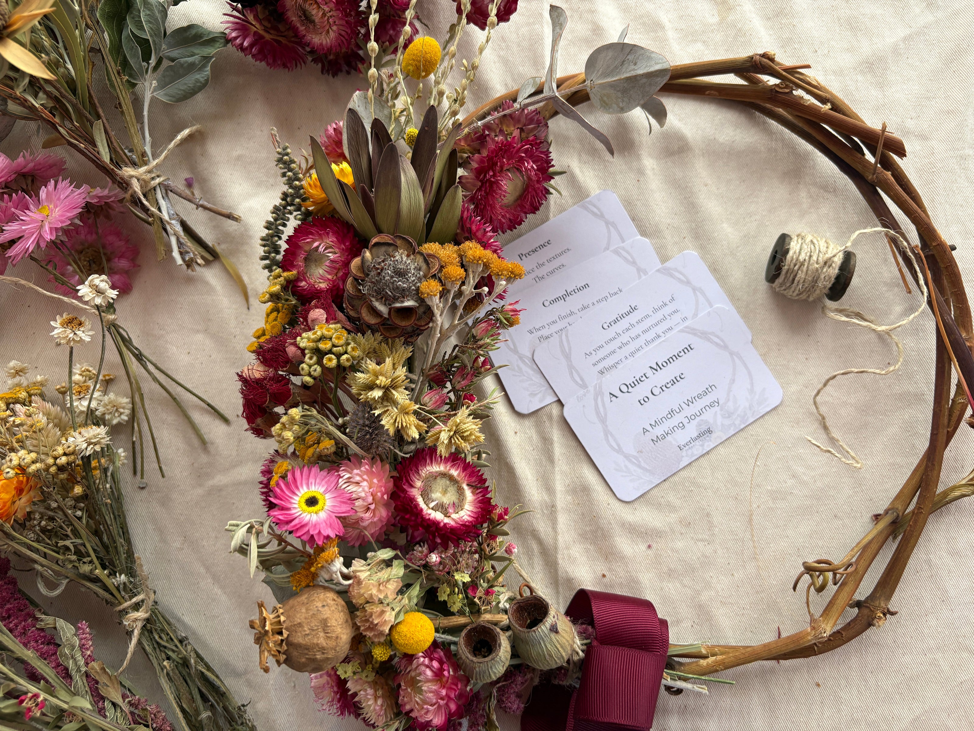 Dried flower wreath with a ribbon on a textured surface