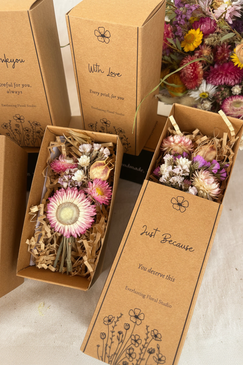Brown gift boxes with dried flowers and decorative text on a light background