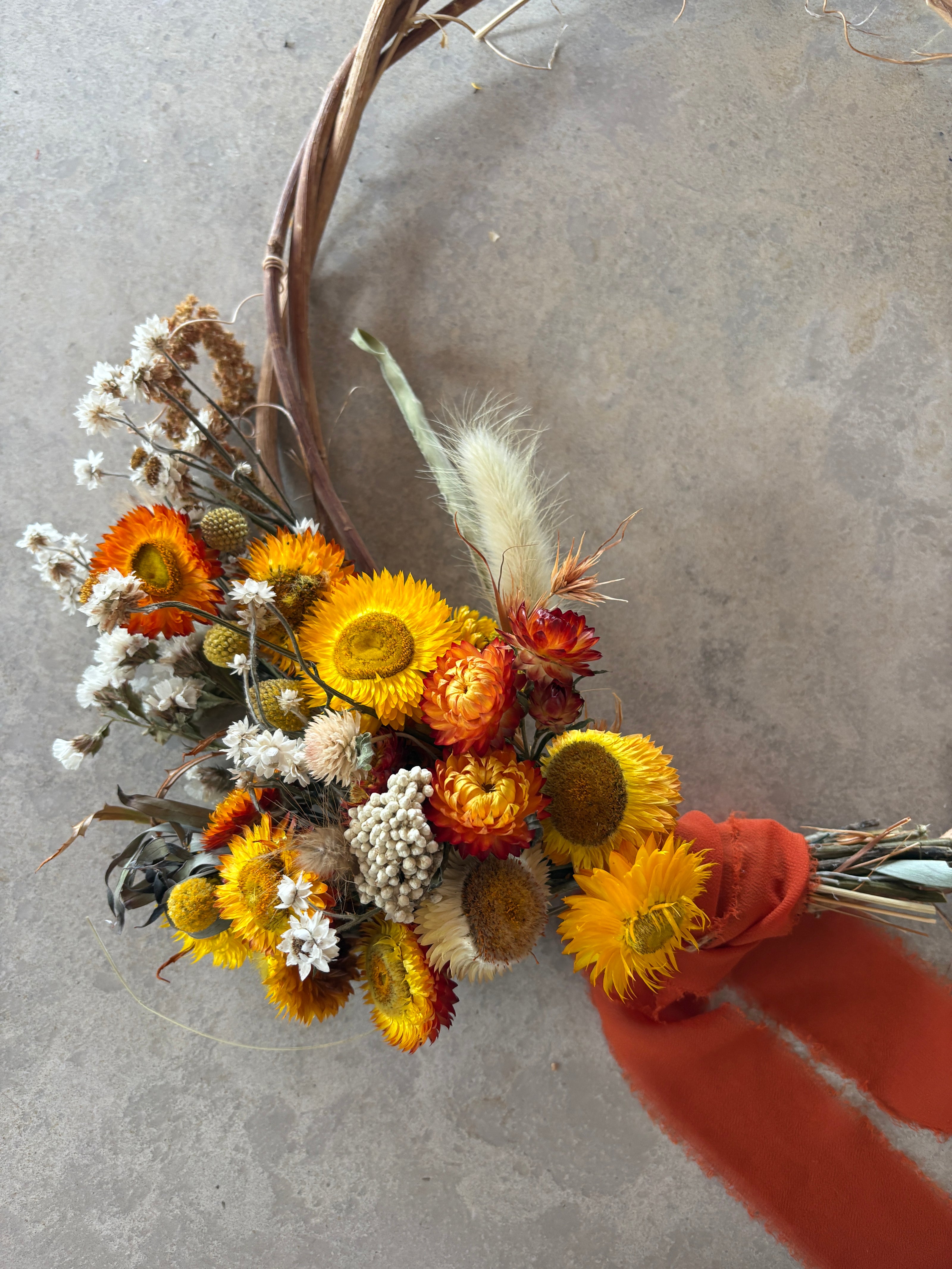 The Remembrance Wreath hanging on a wall — everlasting daisies in natural and white tones