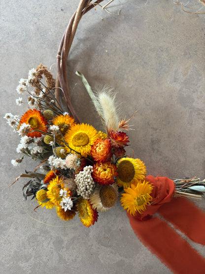 The Remembrance Wreath hanging on a wall — everlasting daisies in natural and white tones